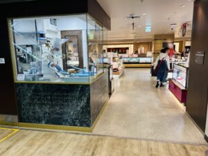 エスカレーターを降りて大丸１階の洋菓子屋さんの前を通過