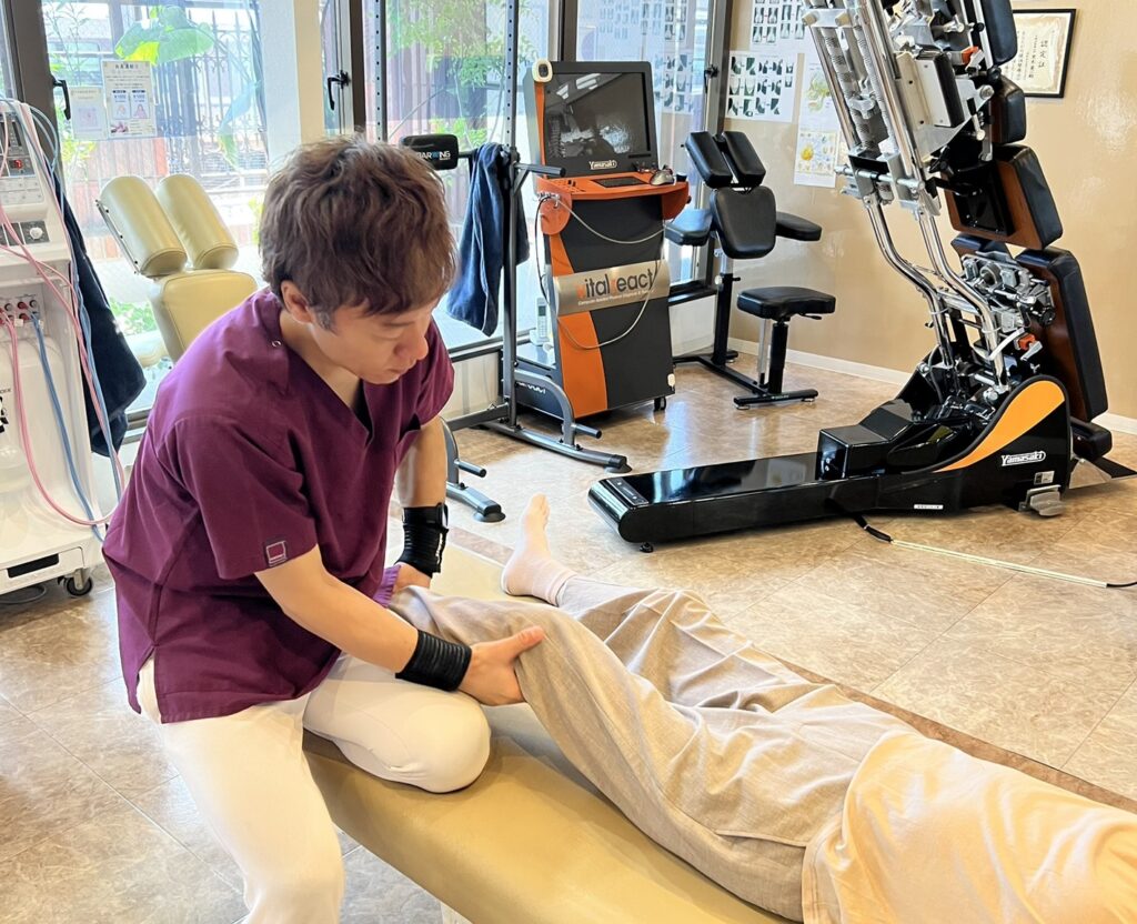 70代女性患者さんの膝の施術をする黒木先生
